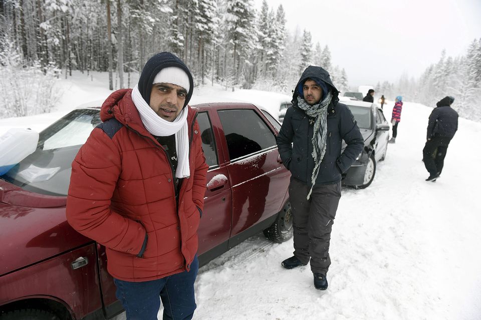 Afghan nationals Nazirulhag (left) and Rahmatullah wait at a boom station three kilometers east of Alakurtti, Russia on January 23, 2016 for permission from the Russian Border Guard  to continue on with their trip to Finland's Salla border crossing.