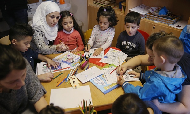 Refugee mothers and children look through games and books in another initiative by the German education ministry, the reading start for refugee children. Photograph: Sean Gallup/Getty Images